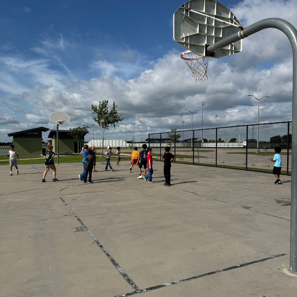 several kids playing basketball at the park