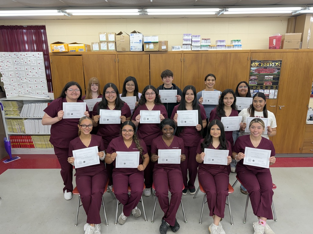 several students in maroon scrubs holding certificates