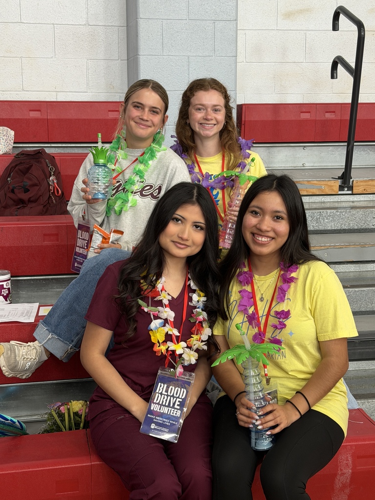 4 students at the blood drive wearing leis