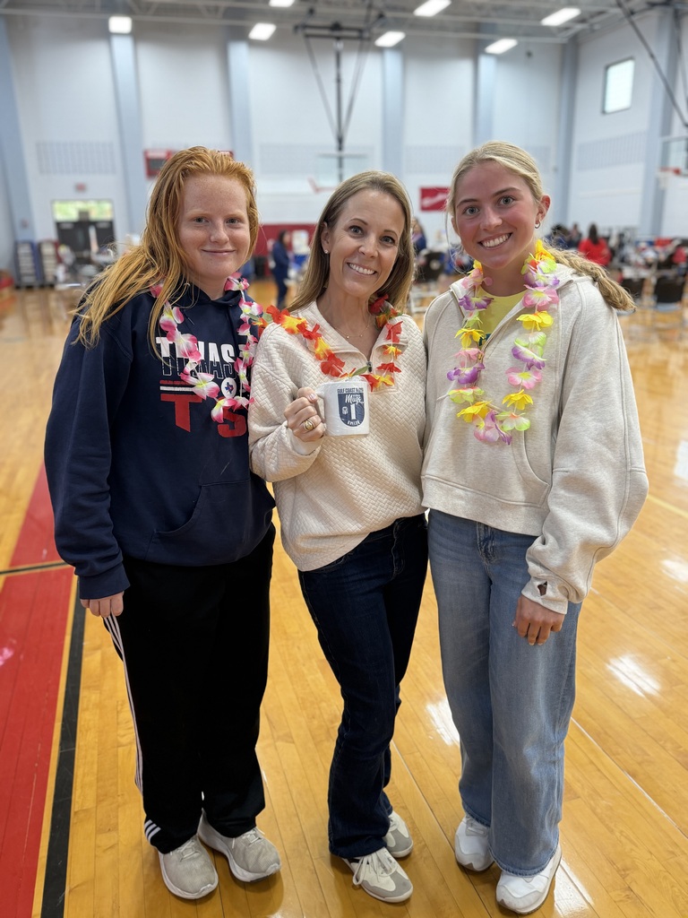 2 students with Gadake holding her mug at the blood drive wearing leis