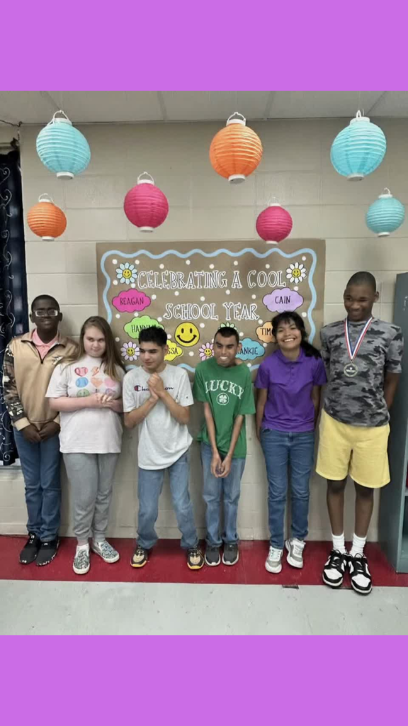 six students by a "celebrating a cool school year" sign
