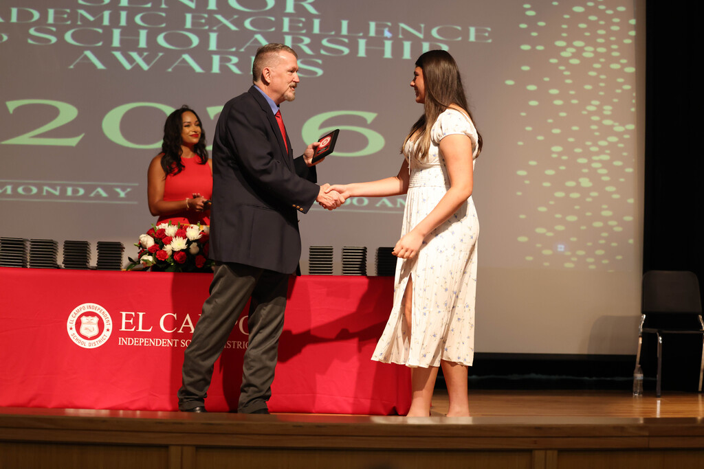 principal shaking hand of a senior girl on stage