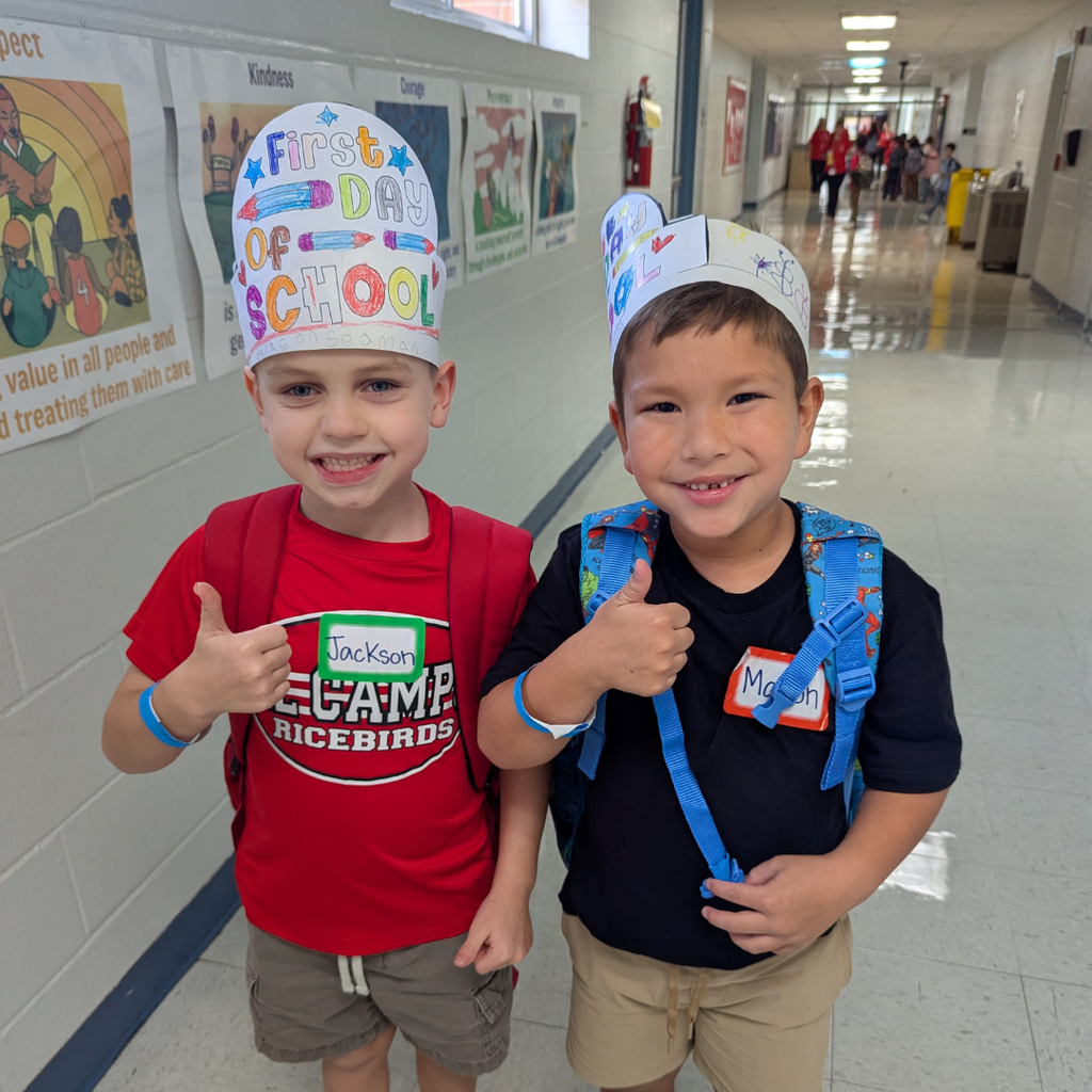 2 smiling boys giving a thumbs up to the camera