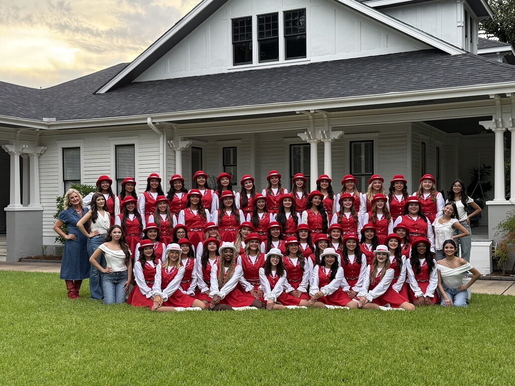 team picture in front of white home