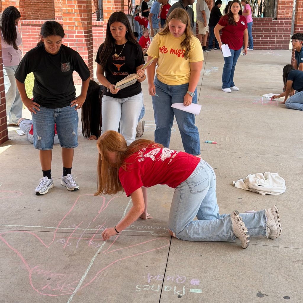 High school students in a Medical Terminology class outline a classmate's body in sidewalk chalk and label anatomical planes and quadrants on the pavement outside.
