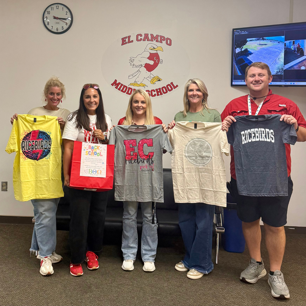4 adults holding shirts at middle school