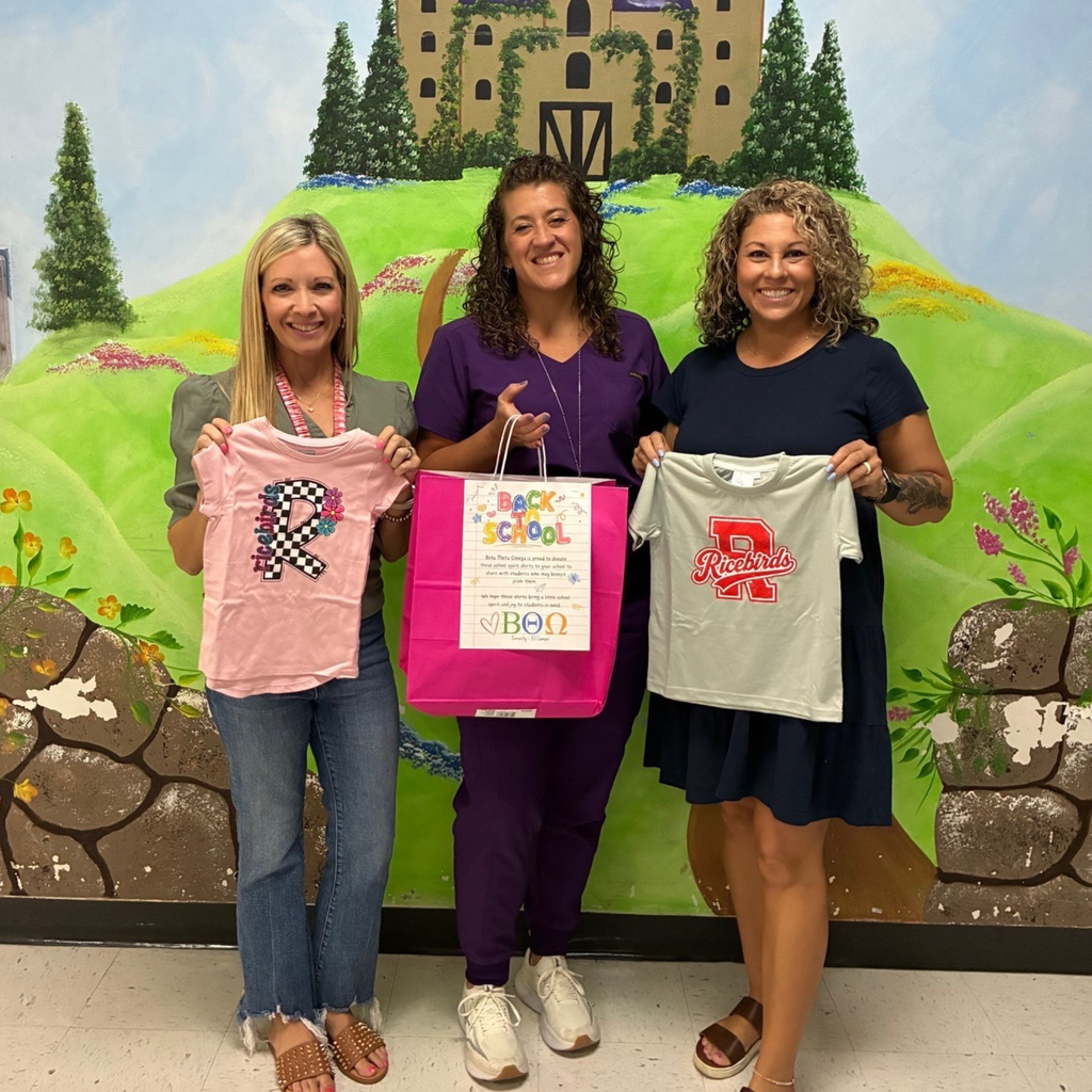 2 adults at myatt accepting a bag of shirts from a lady