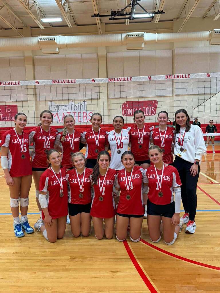 JV volleyball team and coach wearing medals