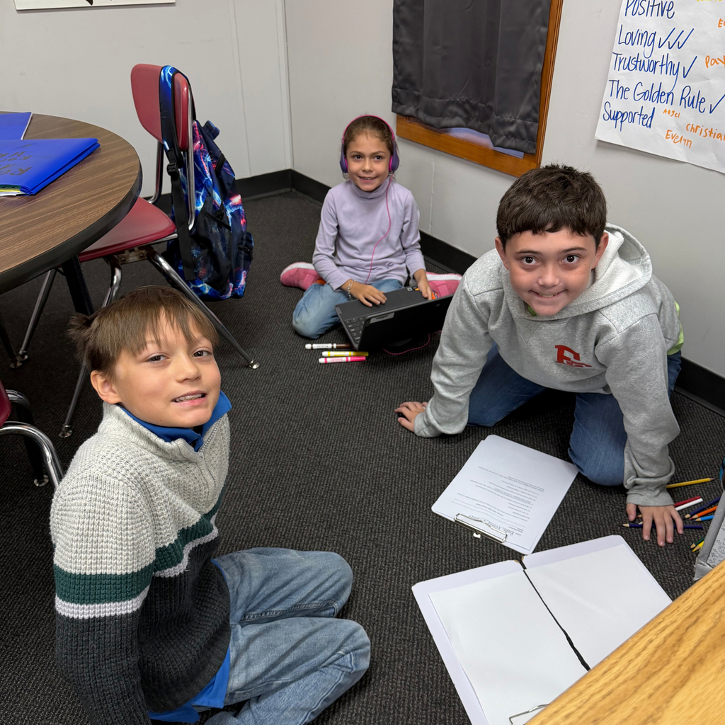 Smiling students working together on a project in the classroom