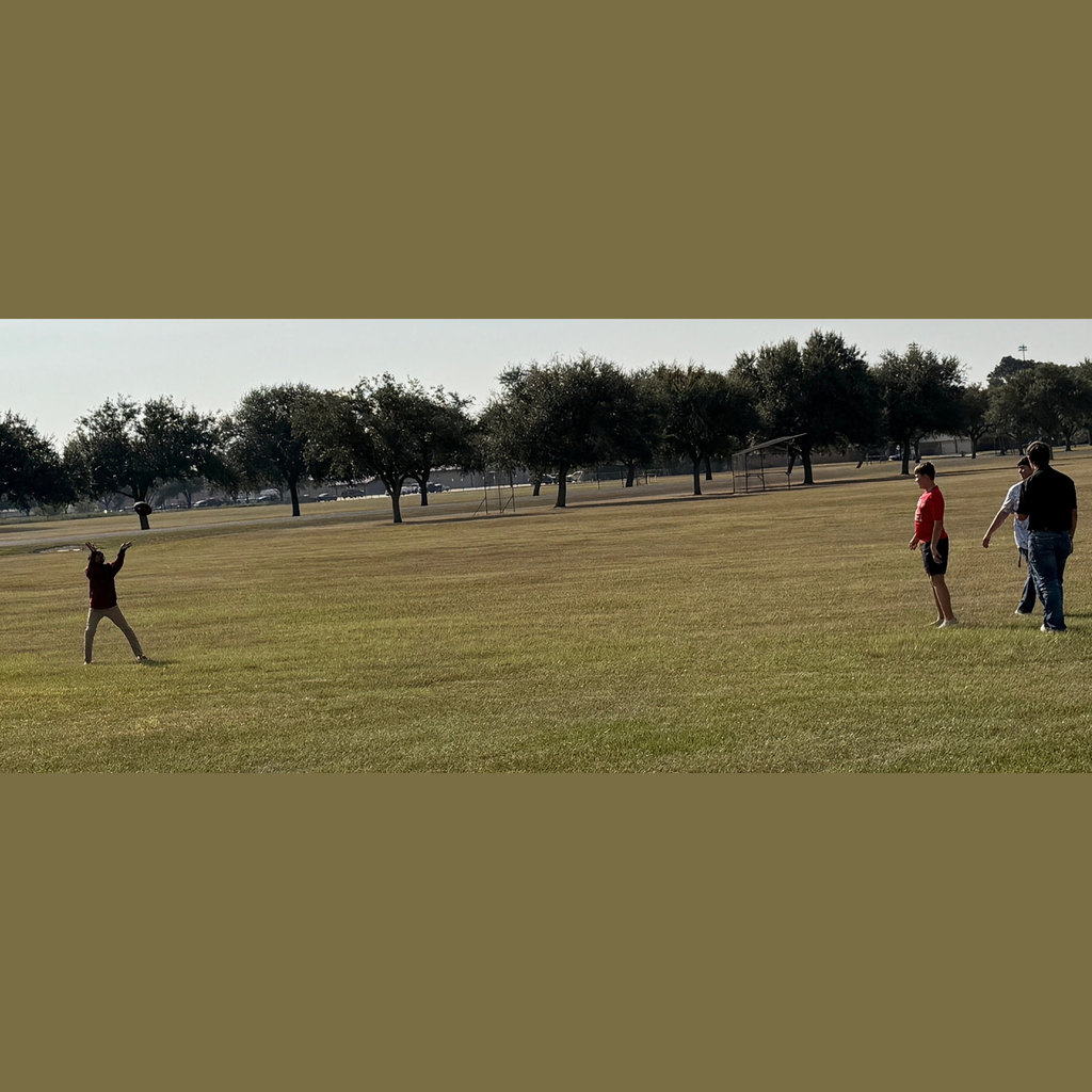 high school boy throwing a football to a small child