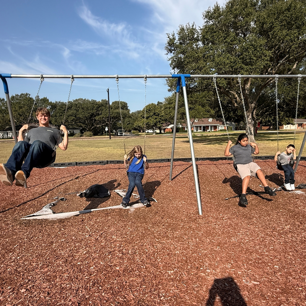 high school boy and elementary kids swinging