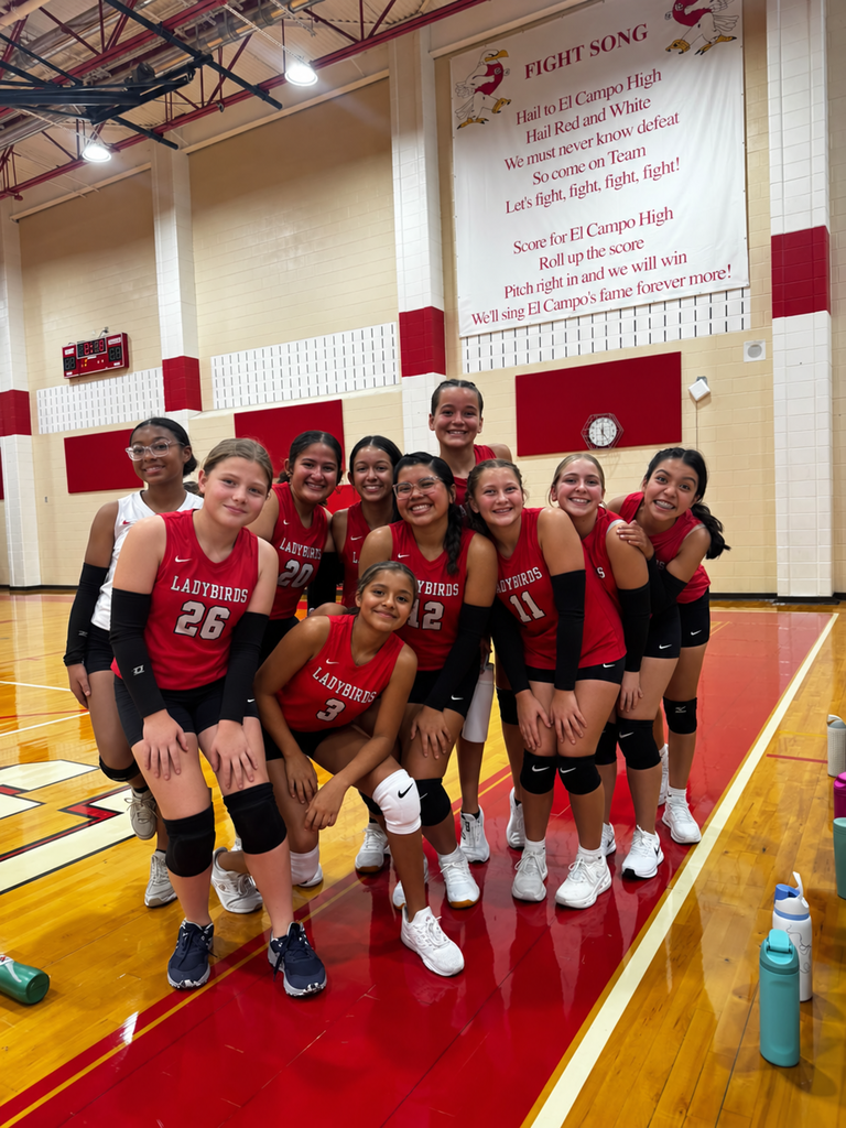 Members of the El Campo Middle School Ladybirds volleyball team4 posing together in uniform indoors.