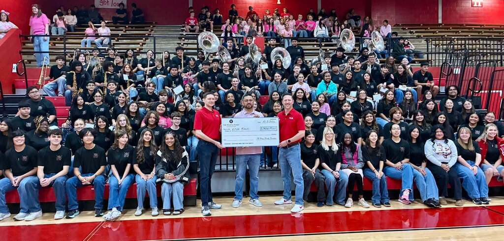 the ricebird and and Band director receiving an enlarged check with Kacer brothers of YK communications