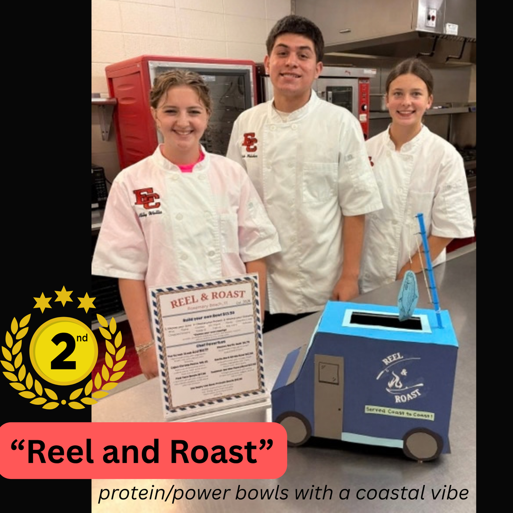 Three culinary arts students stand together behind a counter wearing white chef jackets. A gold badge on the left indicates 2nd place. On the counter sits a framed certificate and a blue paper model of a food truck labeled "Reel & Roast," with text at the bottom reading "protein/power bowls with a coastal vibe."