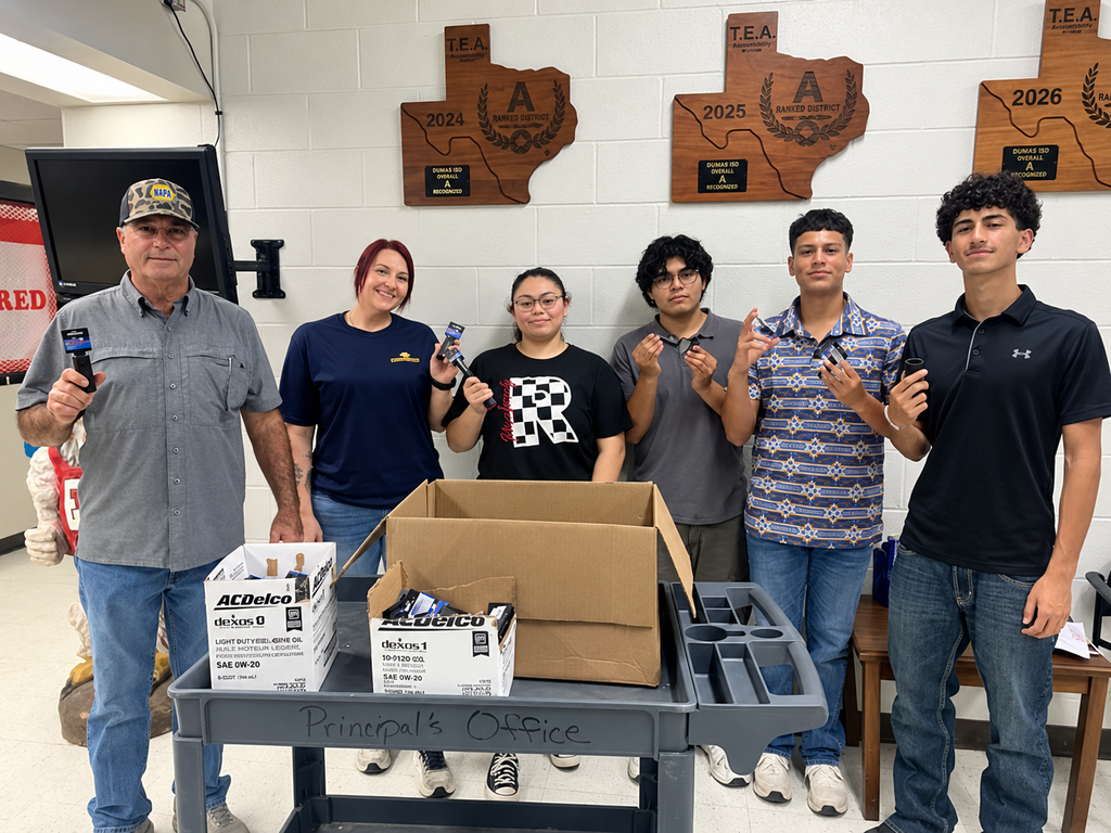 A group of Construction Tech students and an adult stand behind a utility cart with donated ACDelco tool boxes from NAPA El Campo.