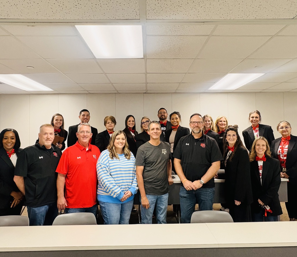 5 high school principals surrounded by the staff wearing black suits with red bow ties