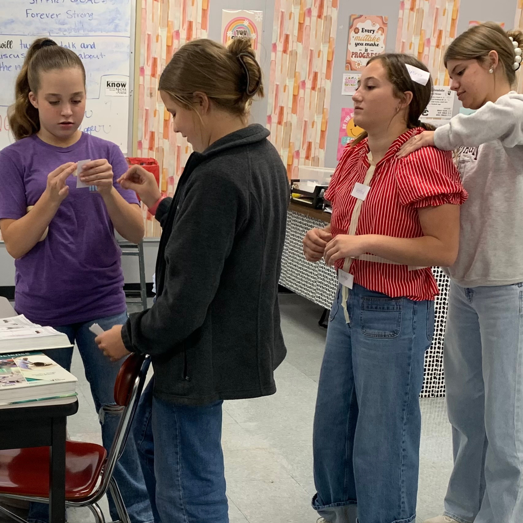 student placing labels on another students body