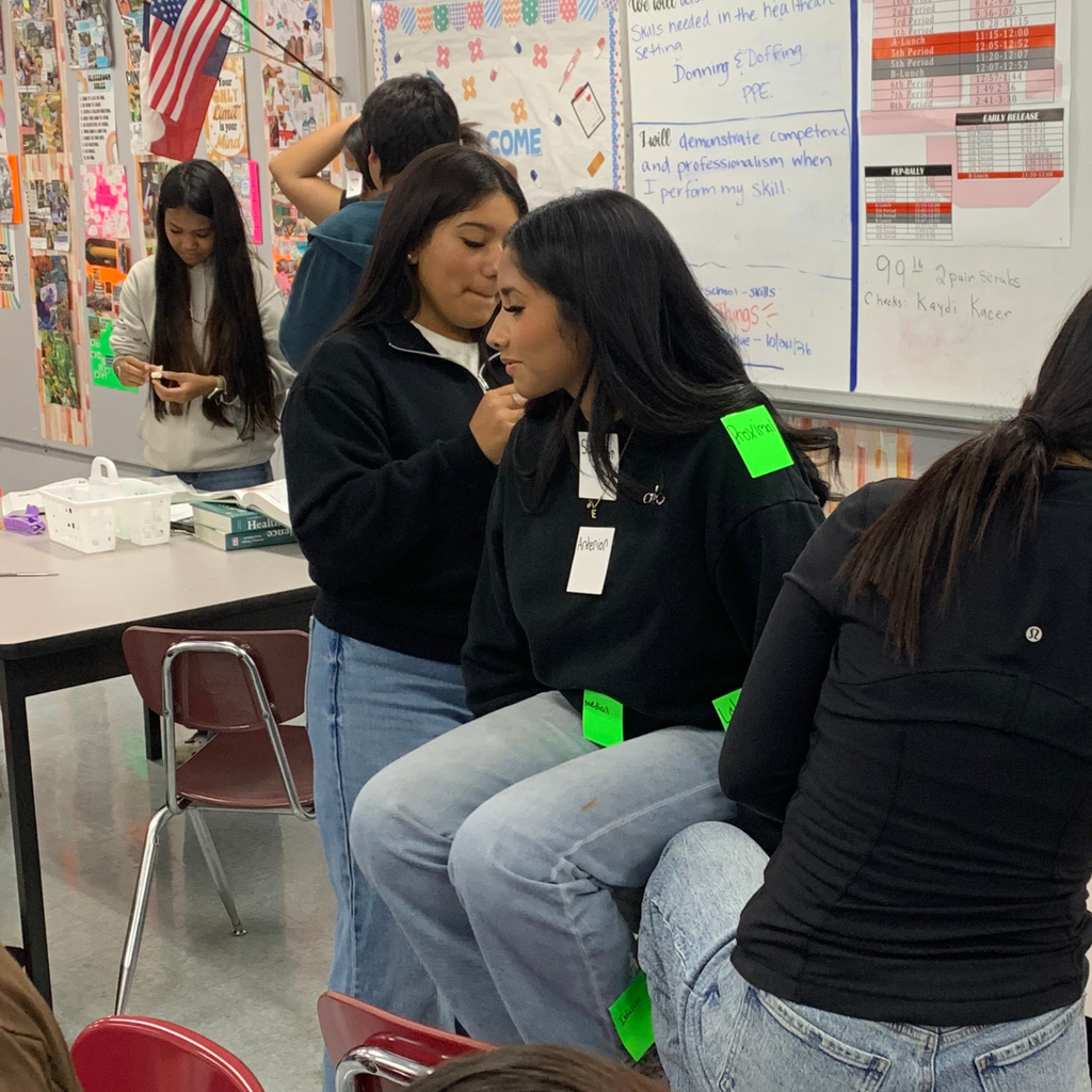 student placing labels on another students body