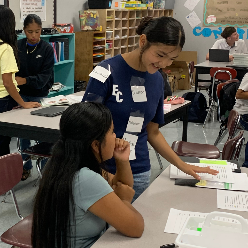student placing labels on another students body