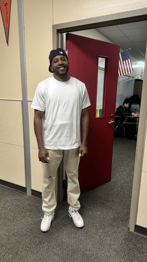 a teacher dressed like a student with his hat backwards