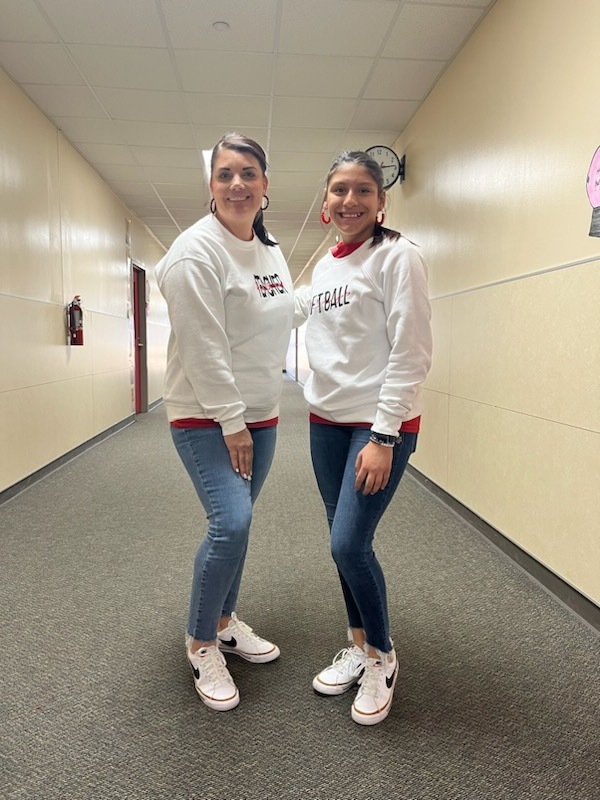 a student dressed like the teacher she is standing with