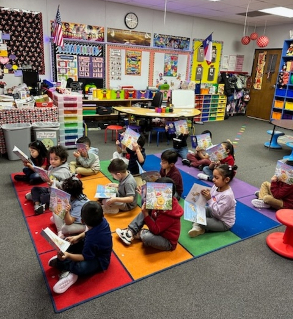 small children sitting on rug reading their book