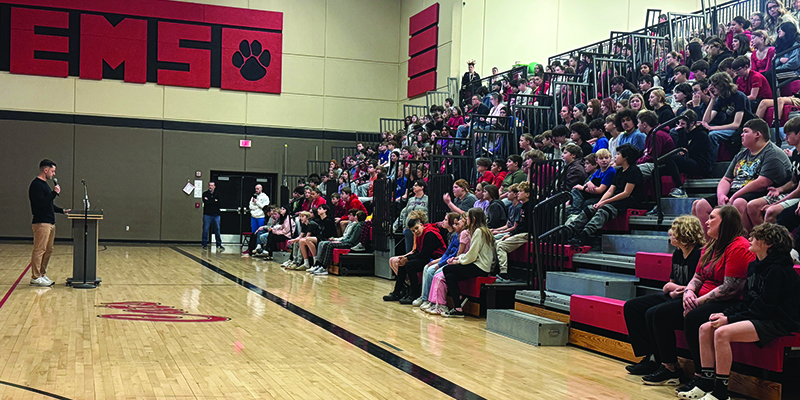 A speaker talks to EMS students in the gym