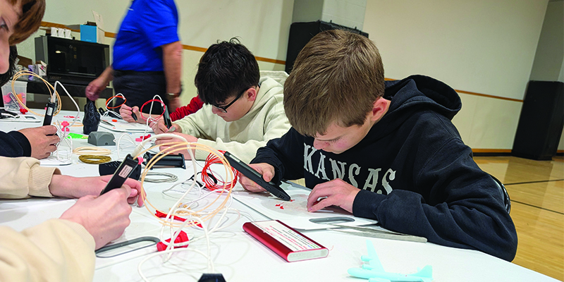 Students focus intently on what they are making with 3D pens