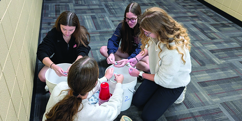 EHS students opening rolls of nickels