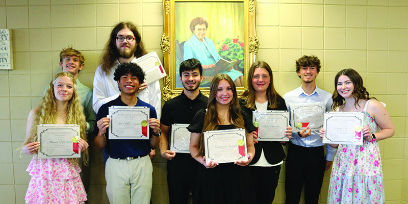 EHS students holding their Myrrl Houck certificates in front of Houck's portrait