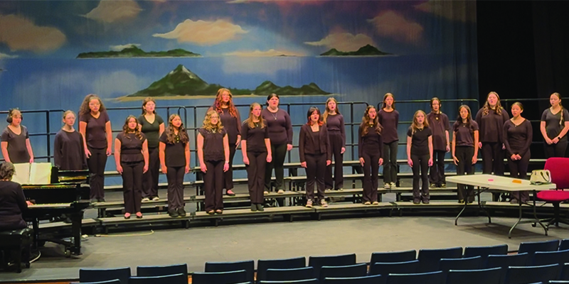 students stand on risers on a stage