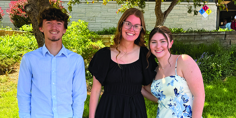 Three EHS students pose in front of a grassy area