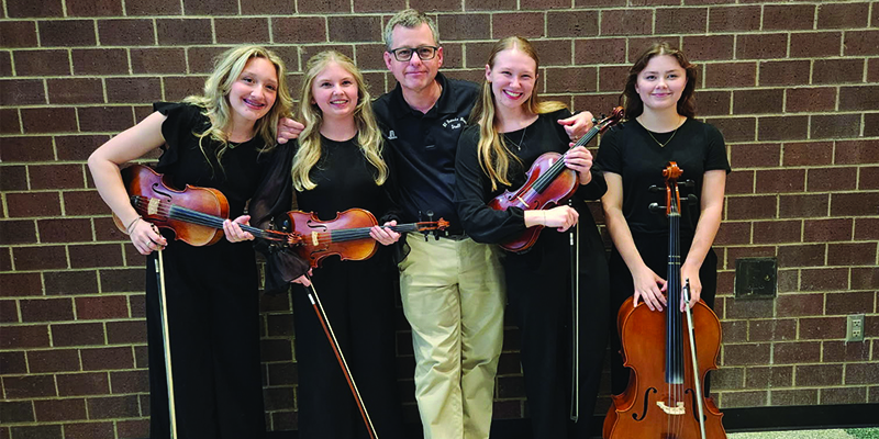 Orchestra Director Kevin Monroe poses with string quartet at state music festival