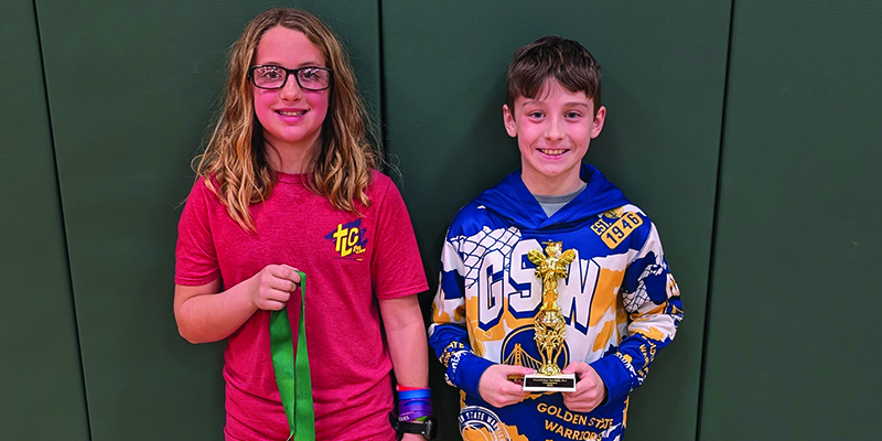 Emery Williams and Camden Scott pose with their trophy and medal for winning first and second place in the Spelling Bee