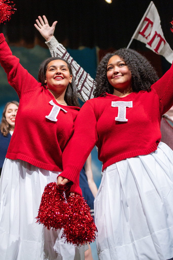 Two girls dressed as cheerleaders in their school musical