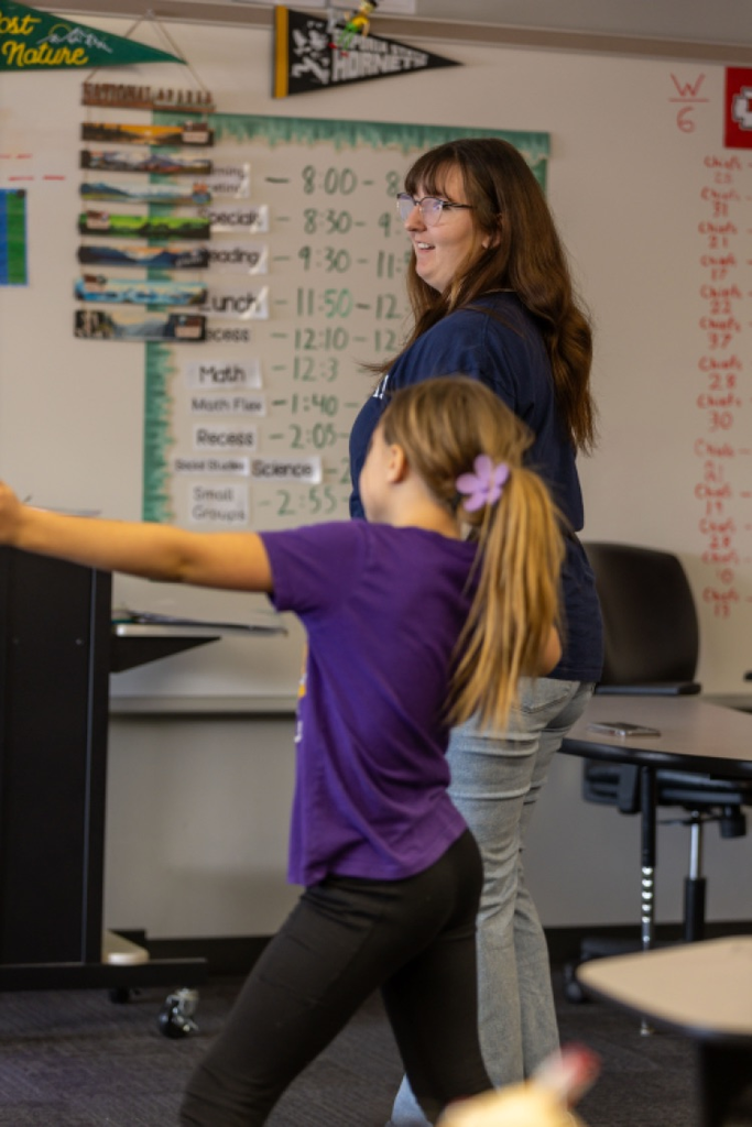 high school student spending time in elementary classroom