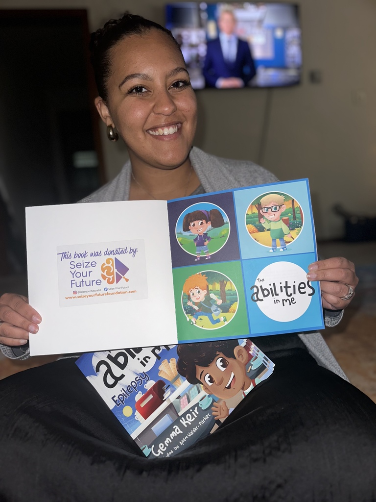 Niomi Ndirangu holding "The Abilities in Me" book that was donated to each elementary library.