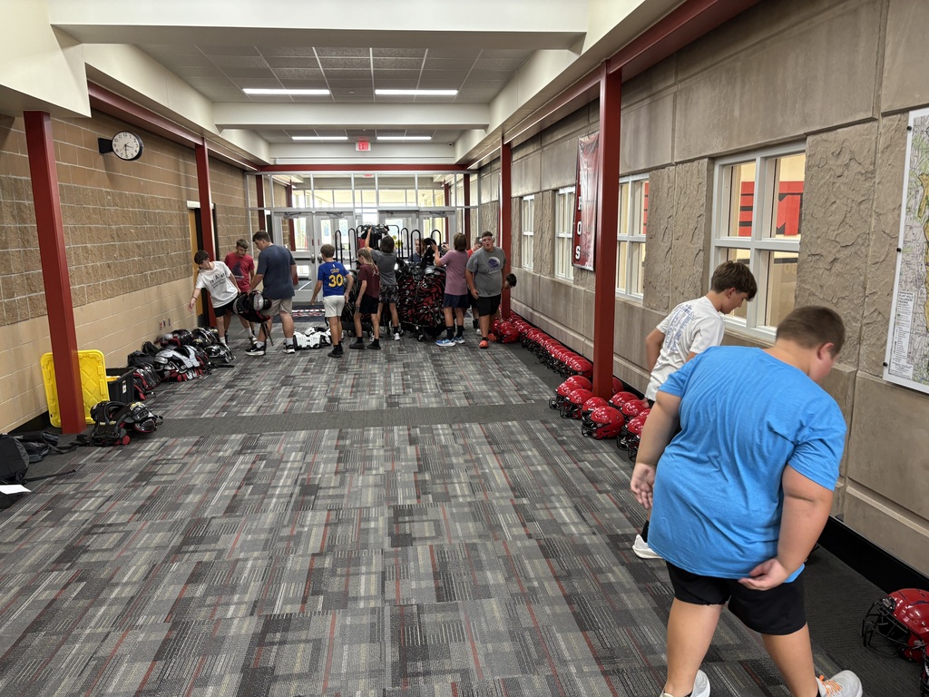 EMS football players prepping for equipemnt checkout in the middle school hallway
