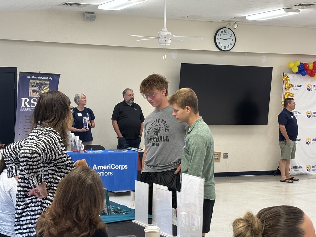 students visit with a booth volunteer
