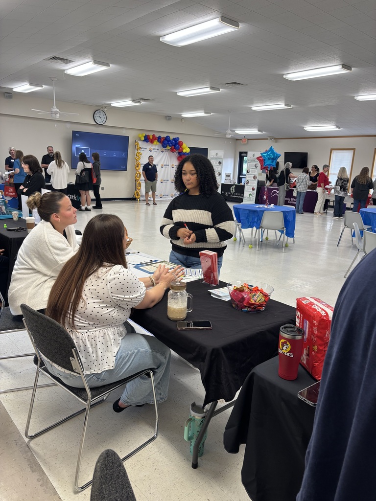 a student talks to two seated adults