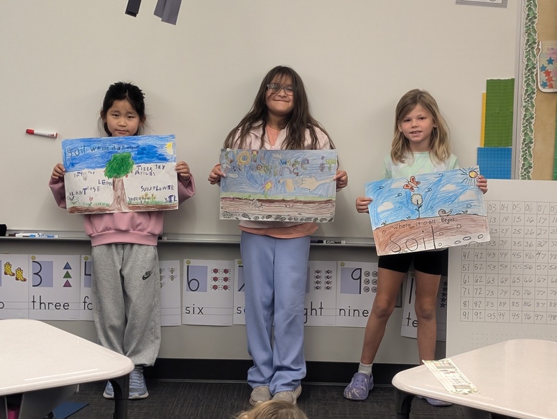 students holding hand-colored posters