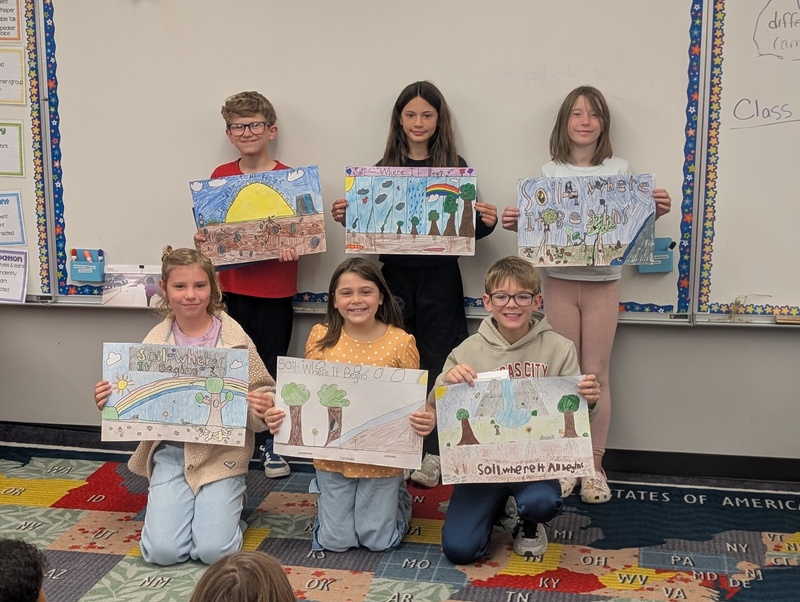 Students holding hand-colored posters