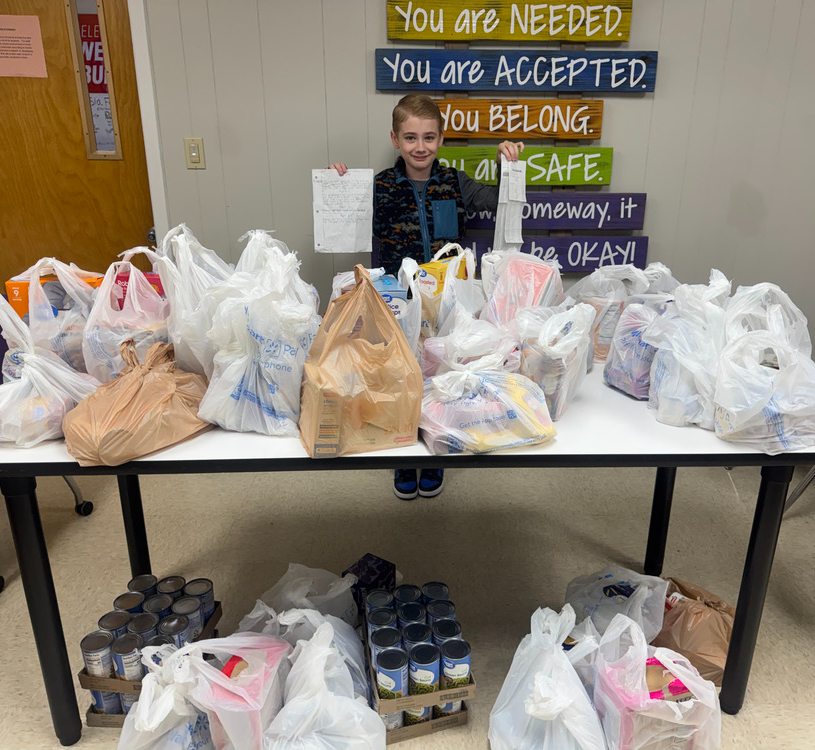 ezra pictured with groceries bought for students in need