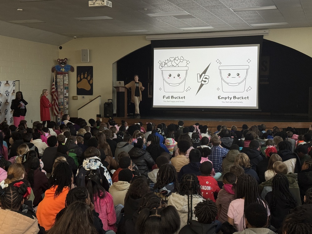 kindness assembly with students listening to the counselor