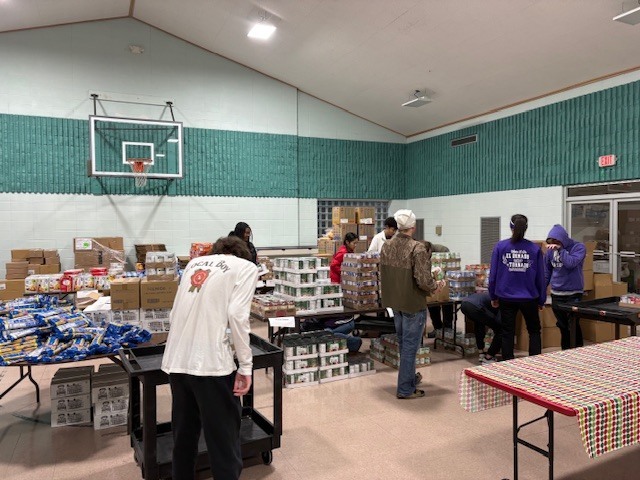Students volunteer to help load food for families.