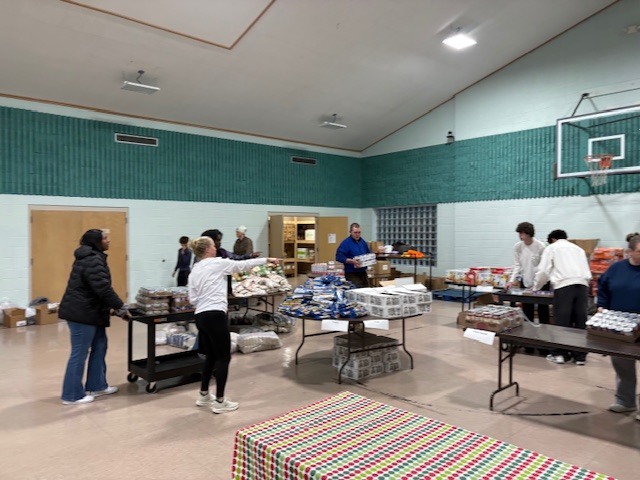 Students volunteer to help load food for families.