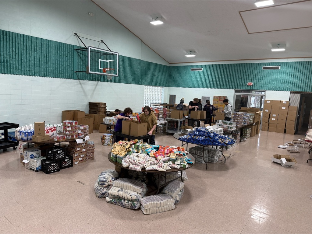 Students volunteer to help load food for families.