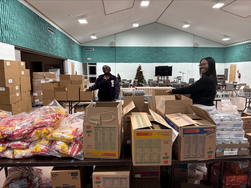 Students volunteer to help load food for families.