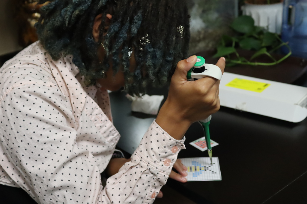 high school students use pipettes and colorful test tubes during a hands-on science lab activity in a classroom.