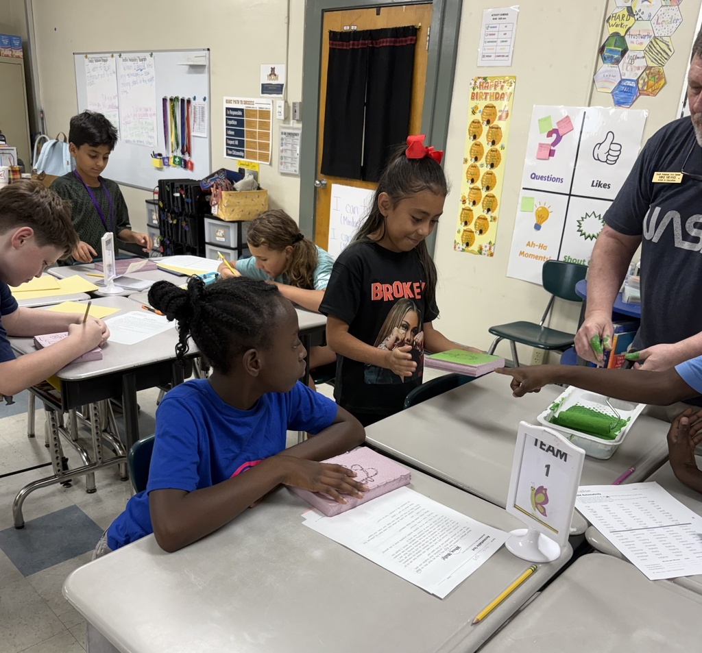 students painting foam pieces on desk for printmaking